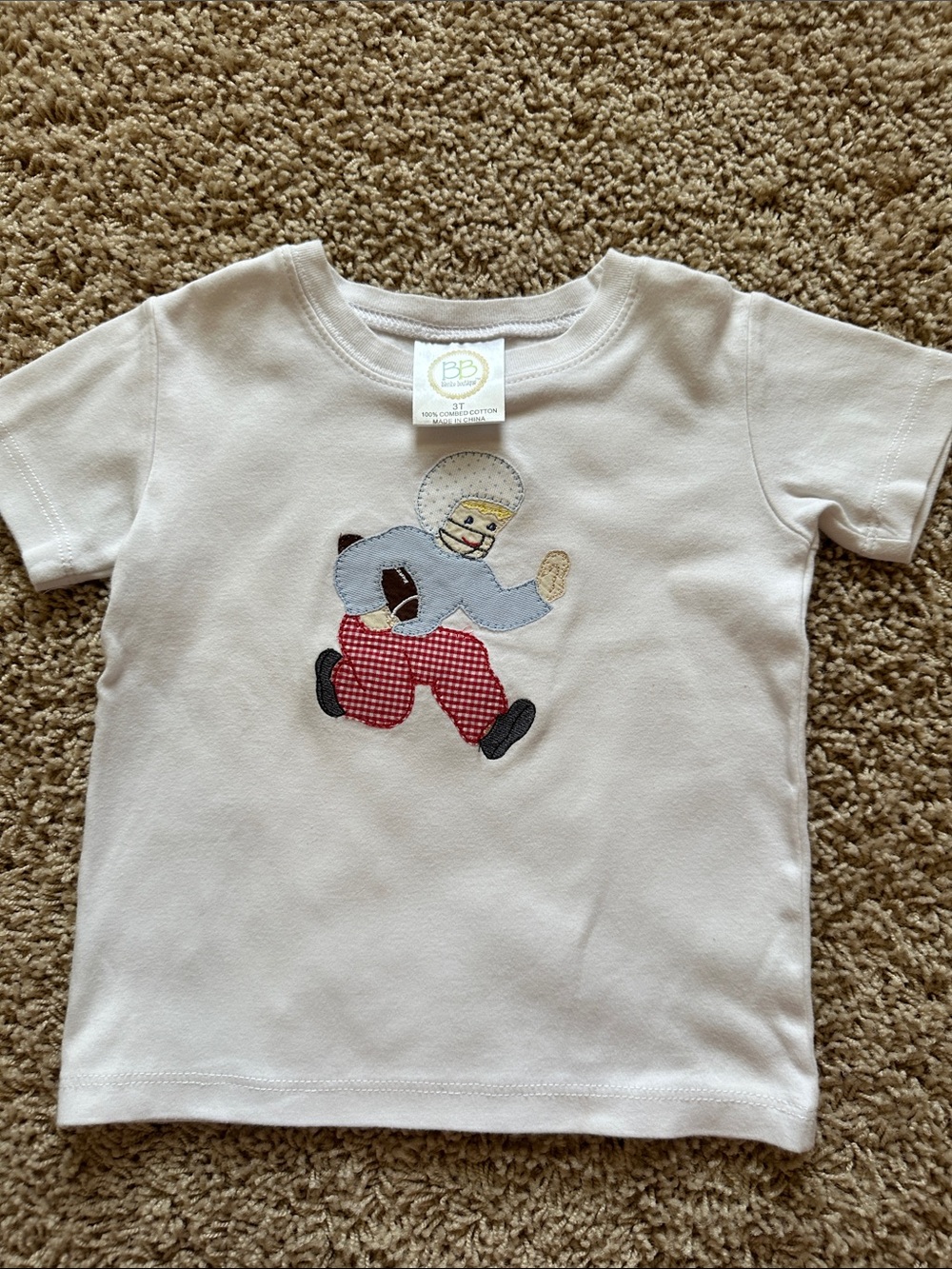 White Kids' Football Appliqué Tee. Appliqué is done on a Blanks Boutique shirt.
